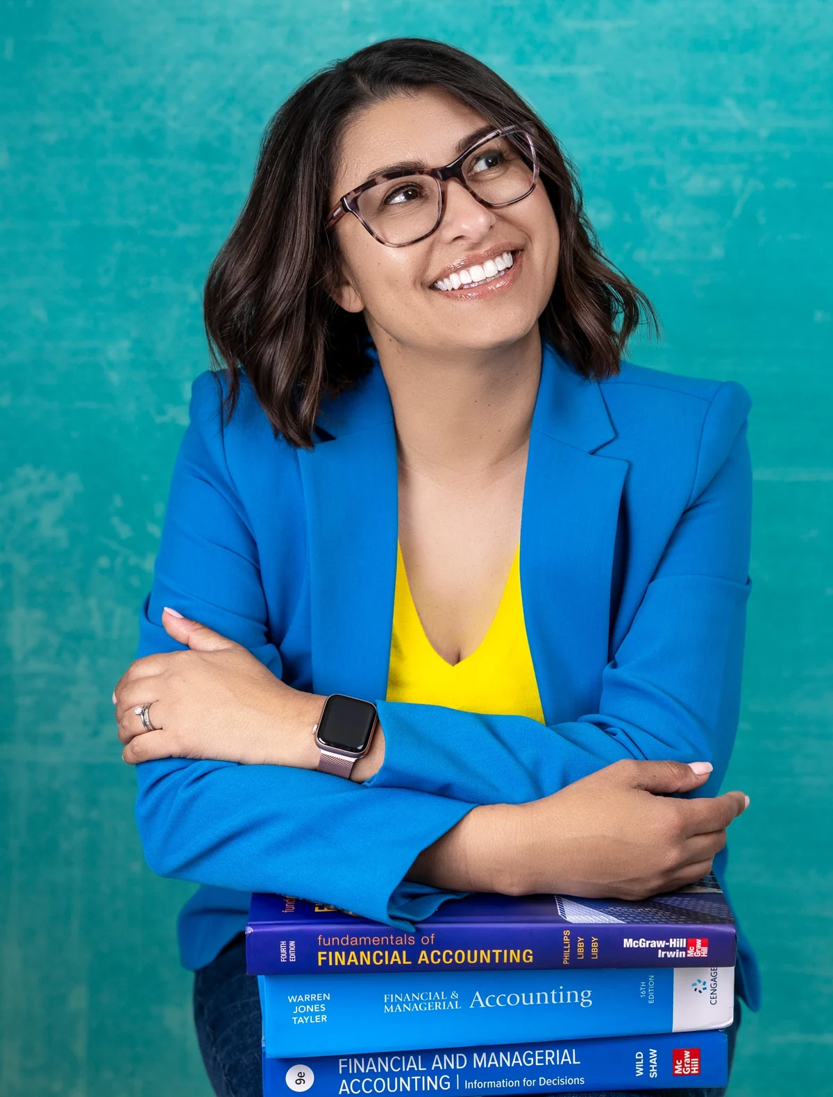 Teresa Thompson smiling above a stack of accounting textbooks.